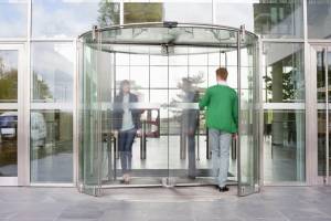 Rotating glass door with people walking through